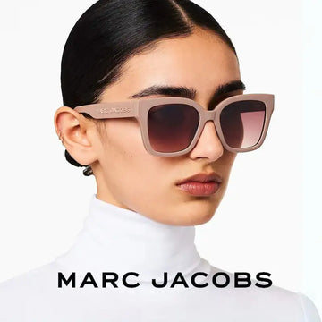 Beige cat-eye sunglasses with gradient brown lenses, featuring the marc jacobs brand name engraved on the temple.