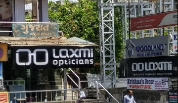 Black and white ’laxmi opticians’ sign with a stylized double-o logo.