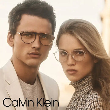 A pair of calvin klein round-framed eyeglasses in a sleek, metallic gold finish.