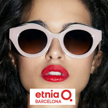 Pastel pink cat-eye sunglasses with dark gradient lenses.